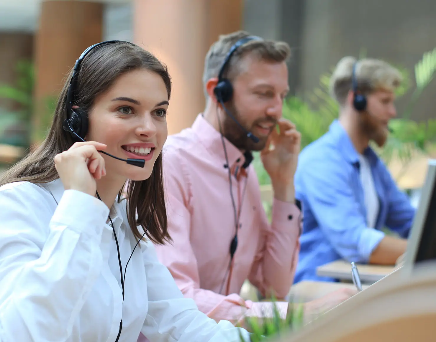 Operatörer på en modern larmcentral arbetar vid datorer med headset